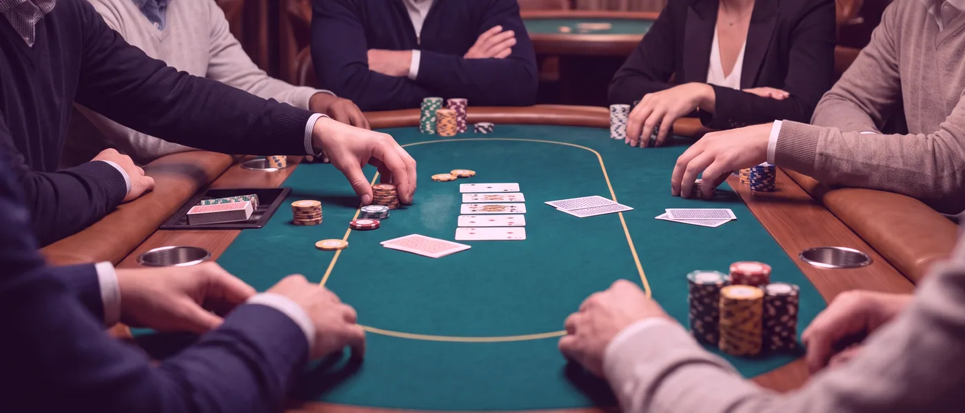 A dealer laying out a hand of cards across a table of deep green felt